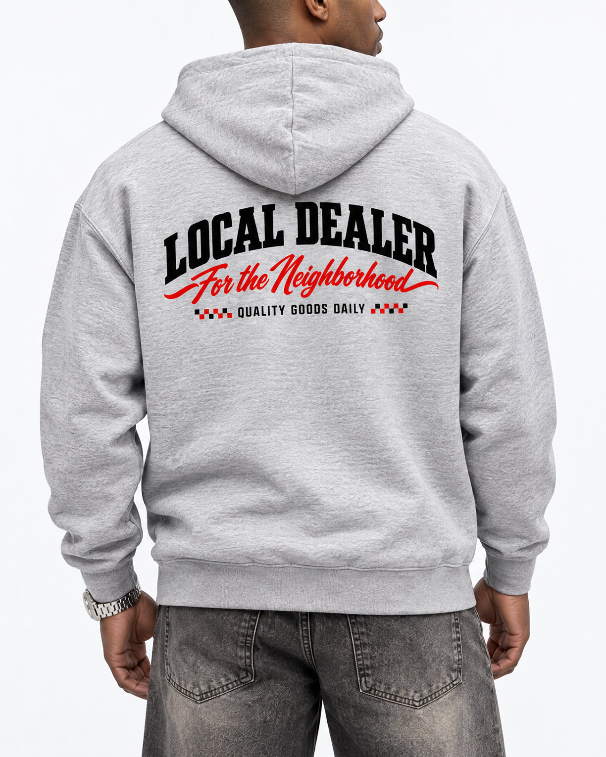 A person shown from the back wearing a light heather gray hoodie with a large graphic print on the back reading 'LOCAL DEALER For the Neighborhood' and 'QUALITY GOODS DAILY' in black and red, paired with gray jeans against a plain white background.