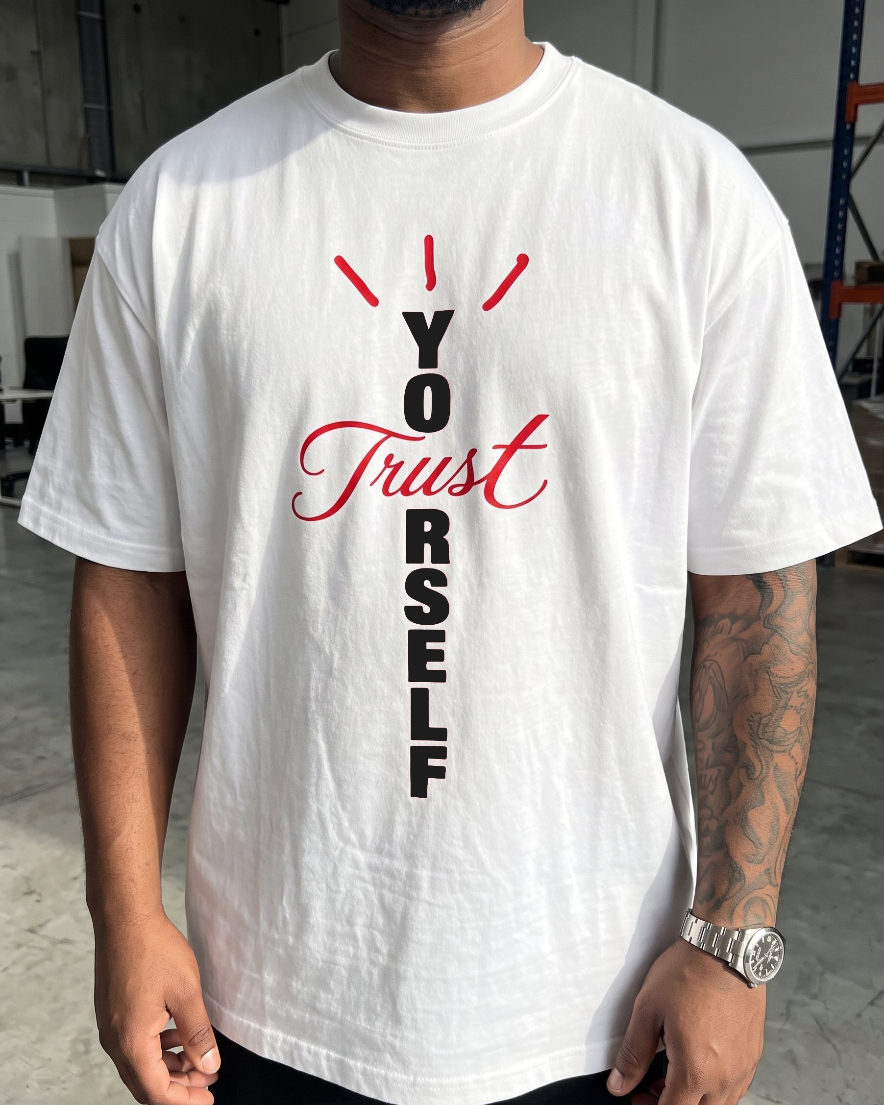 A man wearing a white short-sleeve t-shirt with a graphic print on the front. The graphic features the text 'I Trust You' in black and red lettering, with red slanted lines above.