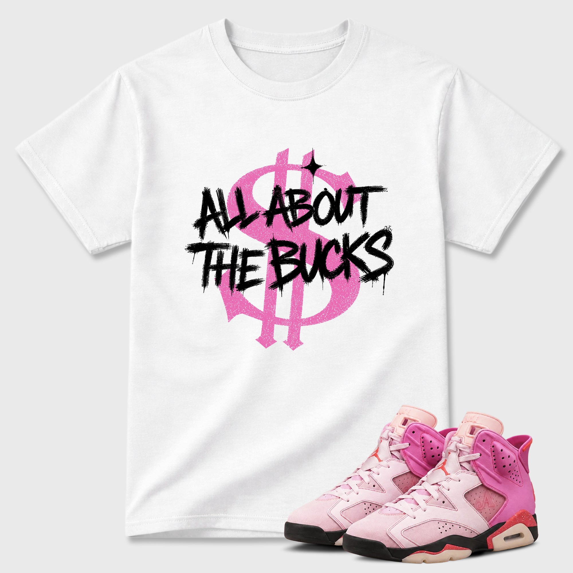 All About the Bucks Graphic T-Shirt featuring original streetwear artwork designed to match the Air Jordan 6 Playful Pink. White 1 Graphic T-Shirt.