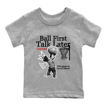 Ball First Talk Later baby and kids t-shirt crafted for little sneakerheads to shine with the Air Jordan 4 White Cement sneakers, displayed in Heather Grey 2.