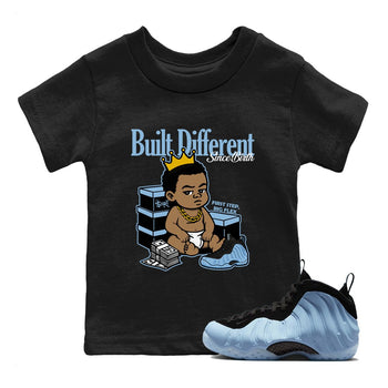 Built Different Since Birth baby and kids t-shirt crafted for little sneakerheads to shine with the Air Foamposite One Psychic Blue sneakers, displayed in Black 1.