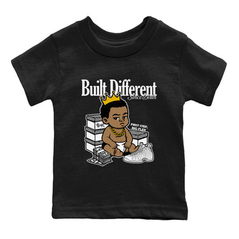 Built Different Since Birth baby and kids t-shirt crafted for little sneakerheads to shine with the Air Foamposite One Triple White sneakers, displayed in Black 2.