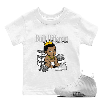 Built Different Since Birth baby and kids t-shirt crafted for little sneakerheads to shine with the Air Foamposite One Triple White sneakers, displayed in White 1.