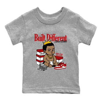 Built Different Since Birth baby and kids t-shirt crafted for little sneakerheads to shine with the Air Force 1 University Red sneakers, displayed in Heather Grey 2.