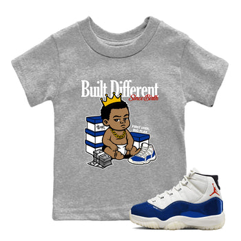 Gray t-shirt with cartoon graphic and white and blue sneakers on a white background