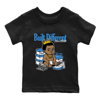 Built Different Since Birth baby and kids t-shirt crafted for little sneakerheads to shine with the Air Jordan 12 White and University Blue sneakers, displayed in Black 2.