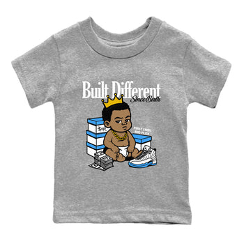 Built Different Since Birth baby and kids t-shirt crafted for little sneakerheads to shine with the Air Jordan 12 White and University Blue sneakers, displayed in Heather Grey 2.