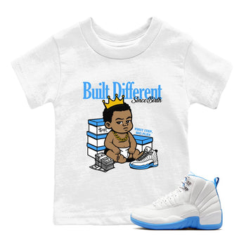 Built Different Since Birth baby and kids t-shirt crafted for little sneakerheads to shine with the Air Jordan 12 White and University Blue sneakers, displayed in White 1.