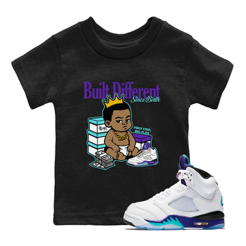 Built Different Since Birth baby and kids t-shirt crafted for little sneakerheads to shine with the Air Jordan 5 Grape sneakers, displayed in Black 1.