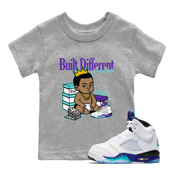 Built Different Since Birth baby and kids t-shirt crafted for little sneakerheads to shine with the Air Jordan 5 Grape sneakers, displayed in Heather Grey 1.