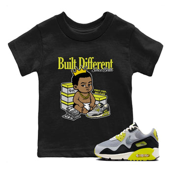 Built Different Since Birth baby and kids t-shirt crafted for little sneakerheads to shine with the Air Max 90 Cyber sneakers, displayed in Black 1.