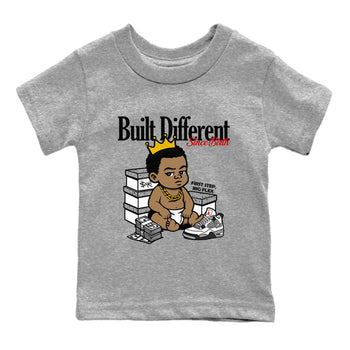 Bulit Different Since Birth baby and kids t-shirt crafted for little sneakerheads to shine with the Air Jordan 4 White Cement sneakers, displayed in Heather Grey 2.