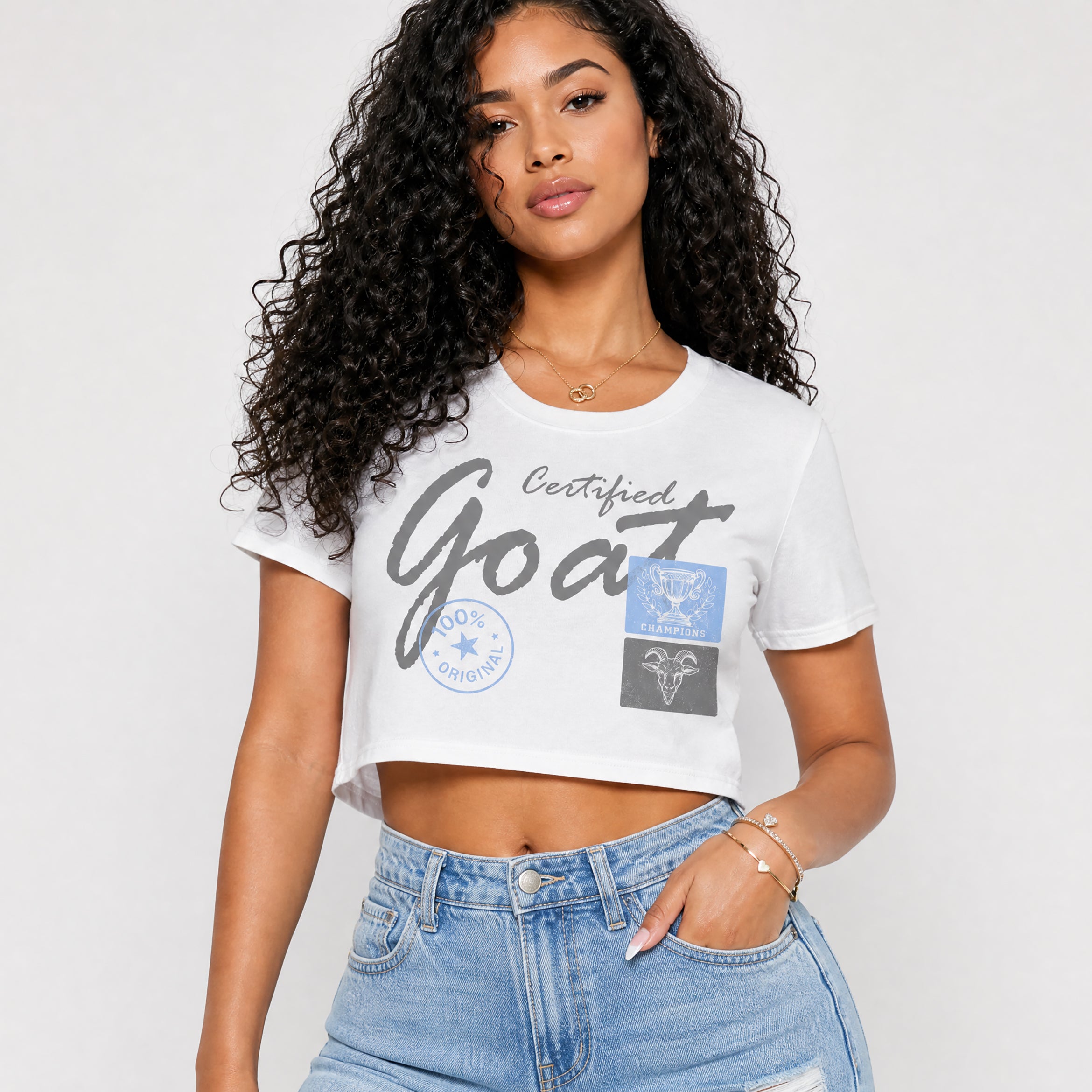 Woman wearing a white t-shirt with certified goat graphics, standing against a plain background