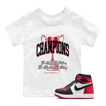 Champions Trophy baby and kids t-shirt crafted for little sneakerheads to shine with the Air Jordan 1 Ruby sneakers, displayed in White 1.