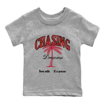 Chasing Dreams baby and kids t-shirt crafted for little sneakerheads to shine with the Air Jordan 1 Ruby sneakers, displayed in Heather Grey 2.