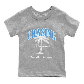 Chasing Dreams baby and kids t-shirt crafted for little sneakerheads to shine with the Air Jordan 12 White and University Blue sneakers, displayed in Heather Grey 2.