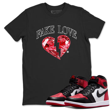 Fake Love sneaker match t-shirt styled to complete your fit with the Air Jordan 1 Ruby sneakers, shown in Black 1.