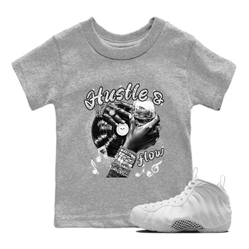 Hustle And Flow baby and kids t-shirt crafted for little sneakerheads to shine with the Air Foamposite One Triple White sneakers, displayed in Heather Grey 1.