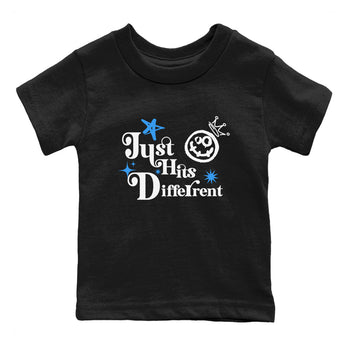 Just Hits Different baby and kids t-shirt crafted for little sneakerheads to shine with the Air Jordan 12 White and University Blue sneakers, displayed in Black 2.