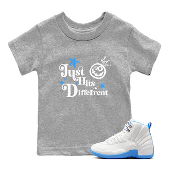 Just Hits Different baby and kids t-shirt crafted for little sneakerheads to shine with the Air Jordan 12 White and University Blue sneakers, displayed in Heather Grey 1.