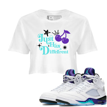 Just Hits Different womens crop tee made to vibe with the Air Jordan 5 Grape sneakers — the perfect match in White 1.
