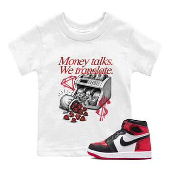 Money Talks We Translate baby and kids t-shirt crafted for little sneakerheads to shine with the Air Jordan 1 Ruby sneakers, displayed in White 1.