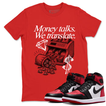 Money Talks We Translate sneaker match t-shirt styled to complete your fit with the Air Jordan 1 Ruby sneakers, shown in Red 1.