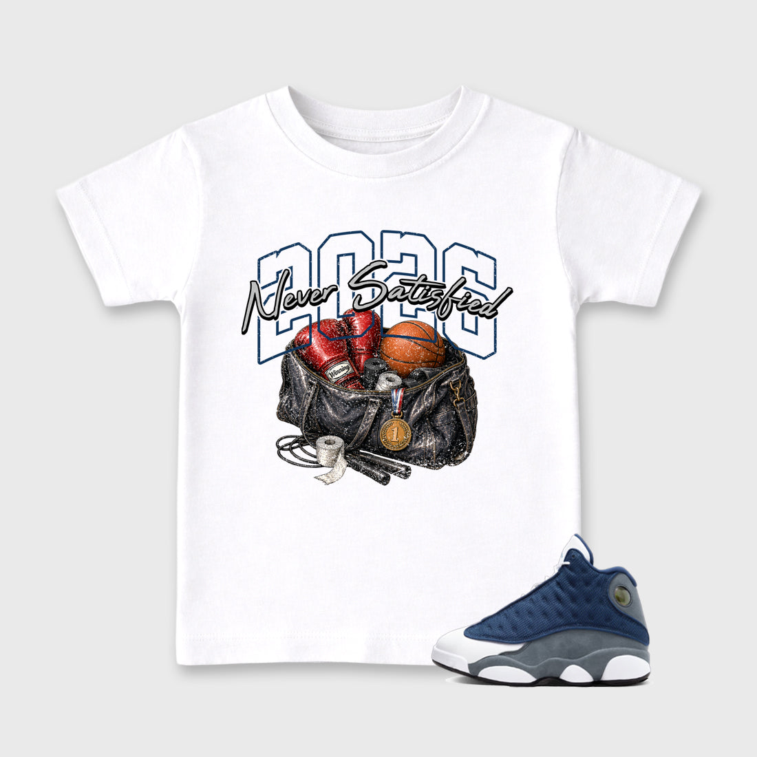 Never Satisfied Baby & Kids Graphic T-Shirt featuring original artwork designed to match the Air Jordan 13 Flint. White 1 Kids Graphic Tee.