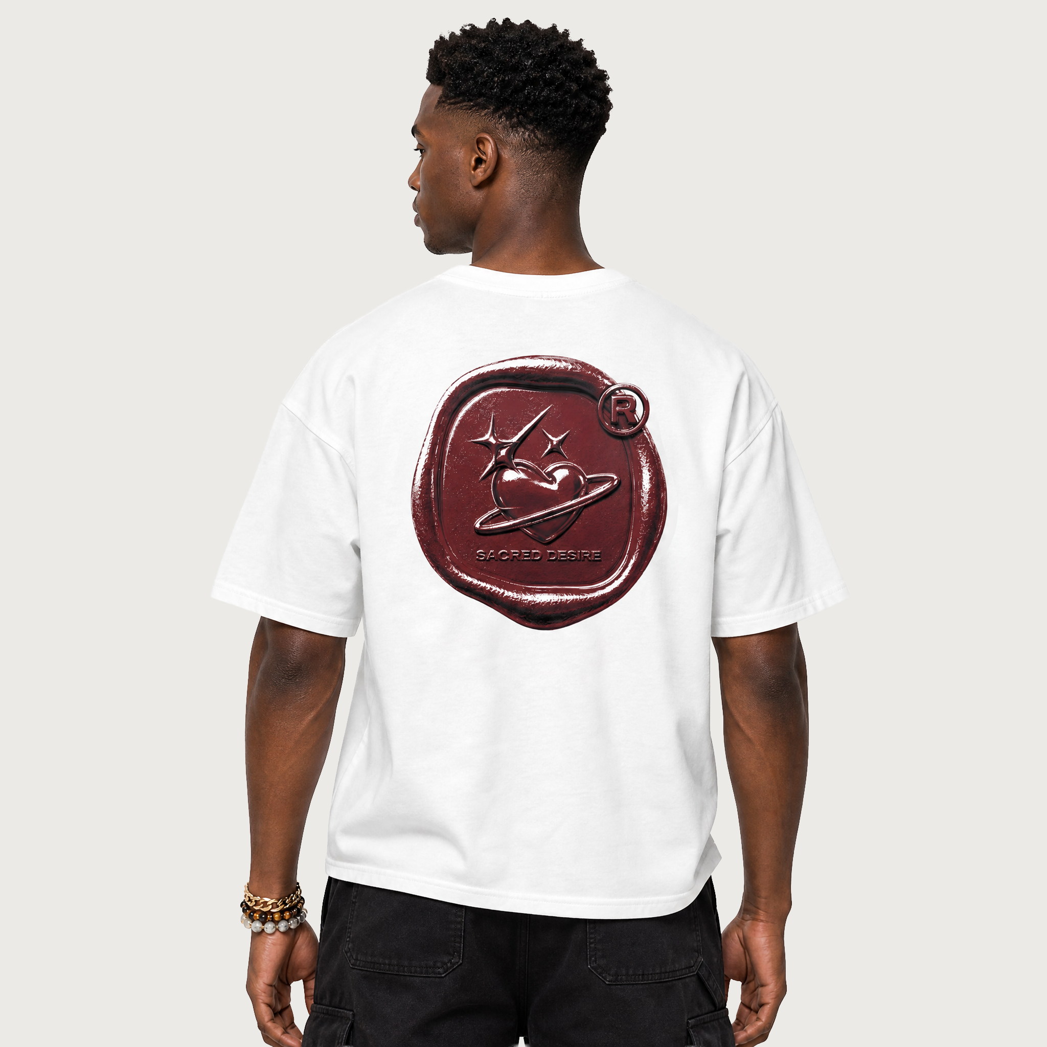 Person wearing a white t-shirt with a red logo on the back against a plain background