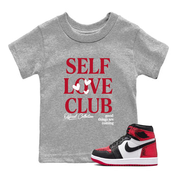 Self Love Club baby and kids t-shirt crafted for little sneakerheads to shine with the Air Jordan 1 Ruby sneakers, displayed in Heather Grey 1.