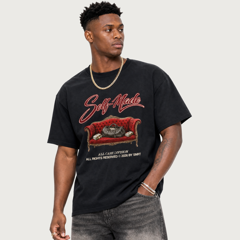 Man wearing a black t-shirt with a graphic design of a red couch and text.