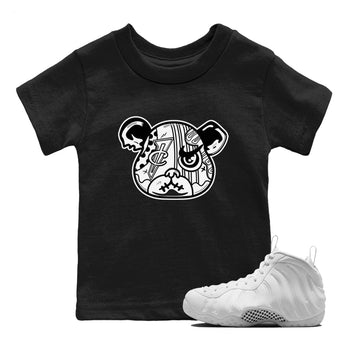 Sneaker Bear Face baby and kids t-shirt crafted for little sneakerheads to shine with the Air Foamposite One Triple White sneakers, displayed in Black 1.