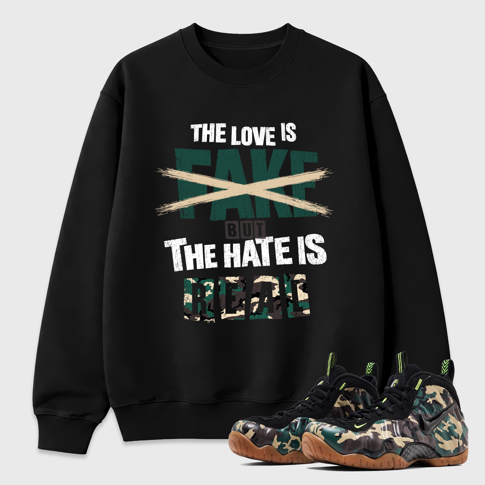 The Love is Fake But the Hate is Real Graphic T-Shirt featuring original streetwear artwork designed to match the Air Foamposite Pro Green Camo. Black 1 Graphic Tee.