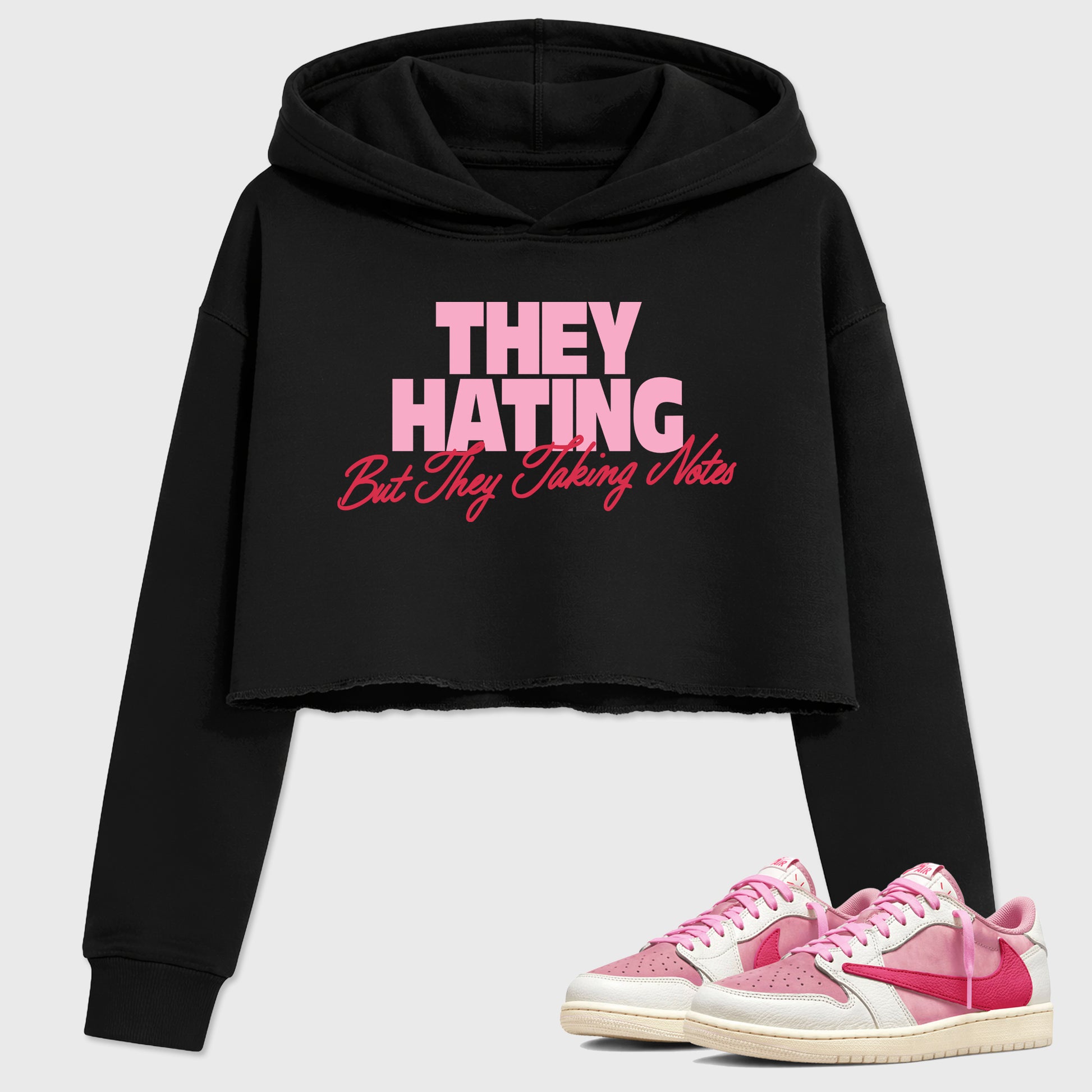 They Hating But Taking Notes women’s crop tee designed to match the Air Jordan 1 Travis Scott Tropical Pink, featuring coordinated Black 1 options for a perfect streetwear vibe.