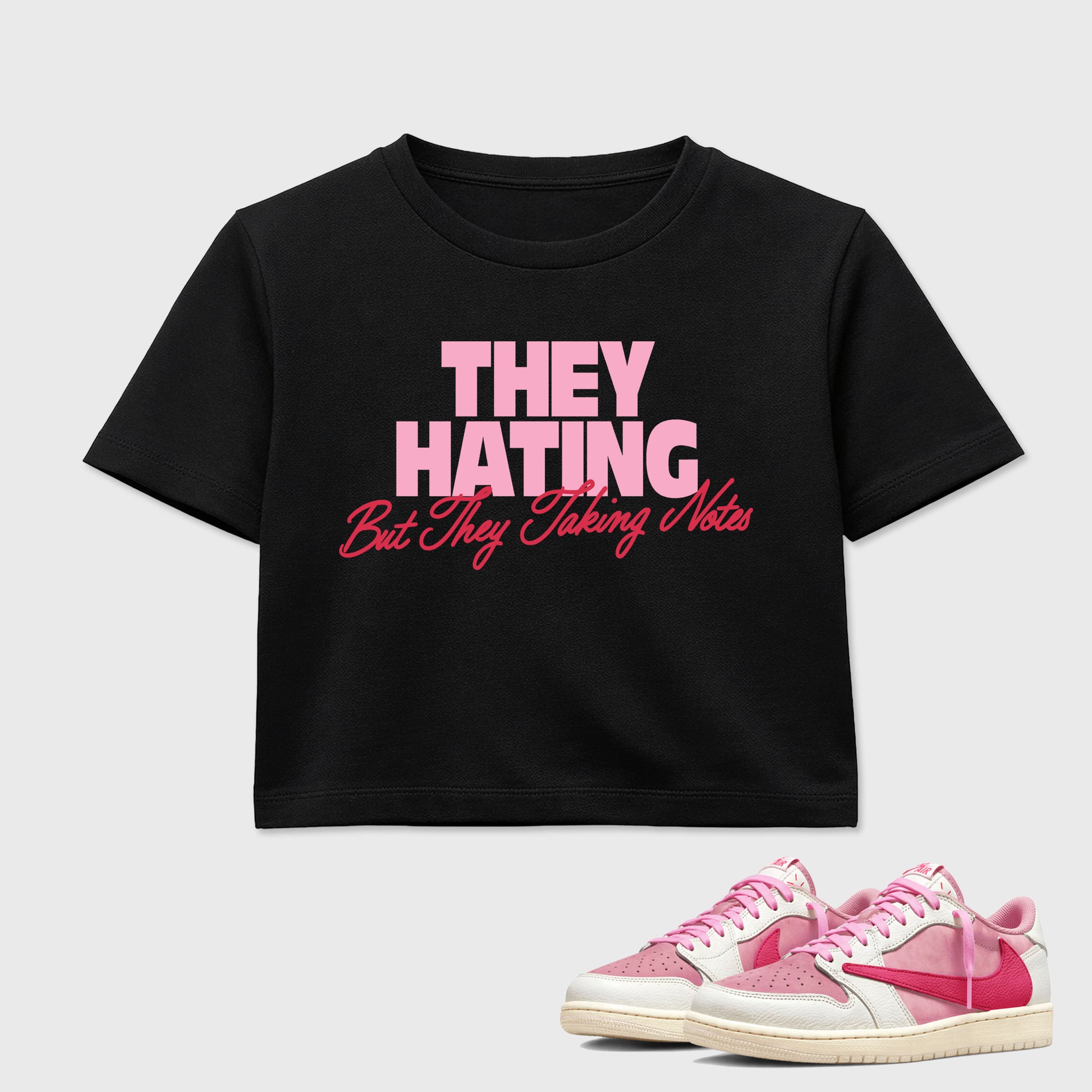 They Hating But Taking Notes women’s crop tee designed to match the Air Jordan 1 Travis Scott Tropical Pink, featuring coordinated Black 1 options for a perfect streetwear vibe.