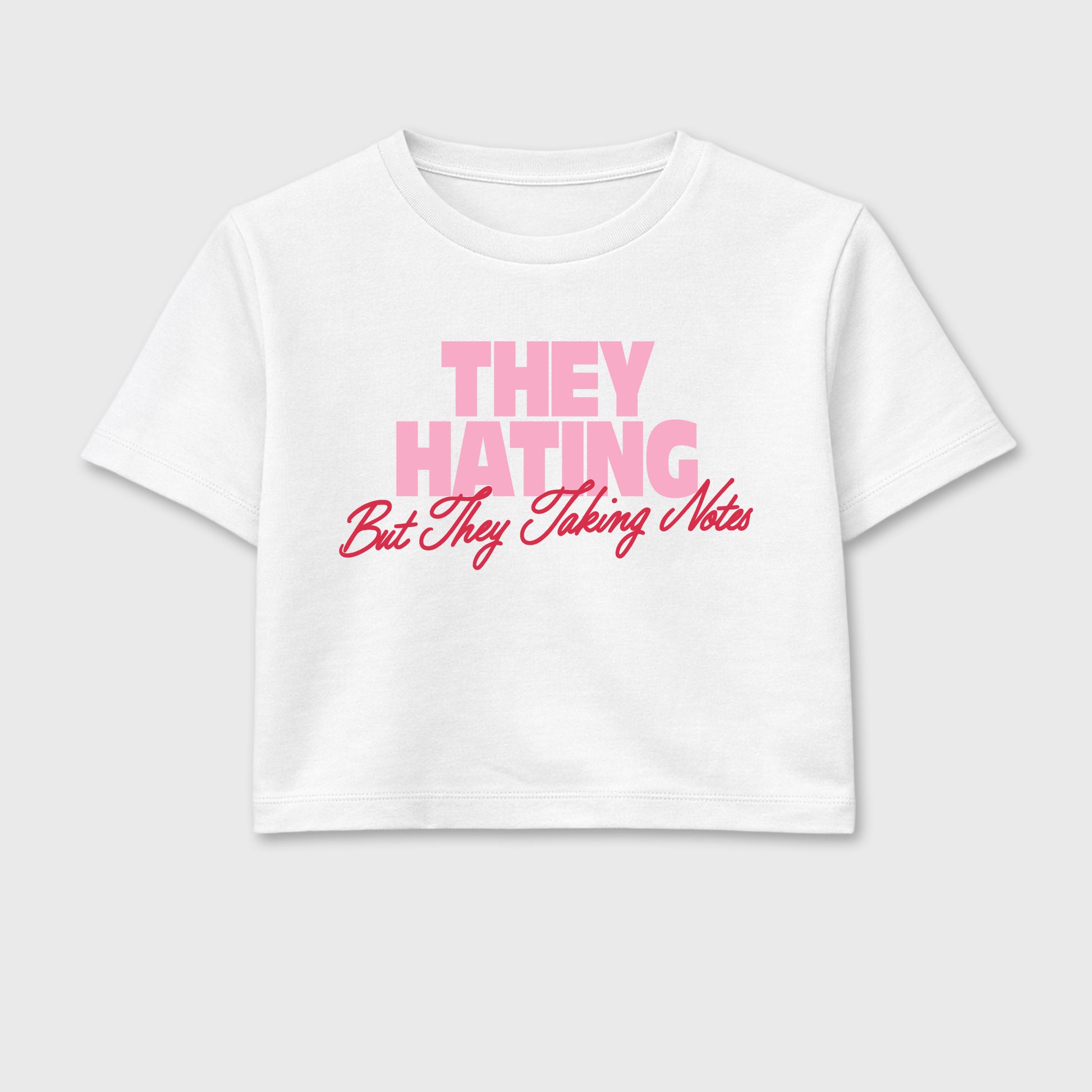 They Hating But Taking Notes women’s crop tee designed to match the Air Jordan 1 Travis Scott Tropical Pink, featuring coordinated White 2 options for a perfect streetwear vibe.