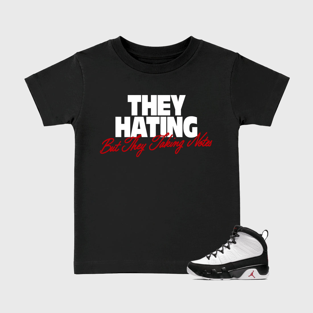 They Hating But Taking Notes Baby & Kids Graphic T-Shirt featuring original artwork designed to match the Air Jordan 9 True Red. Black 1 Kids Graphic Tee.