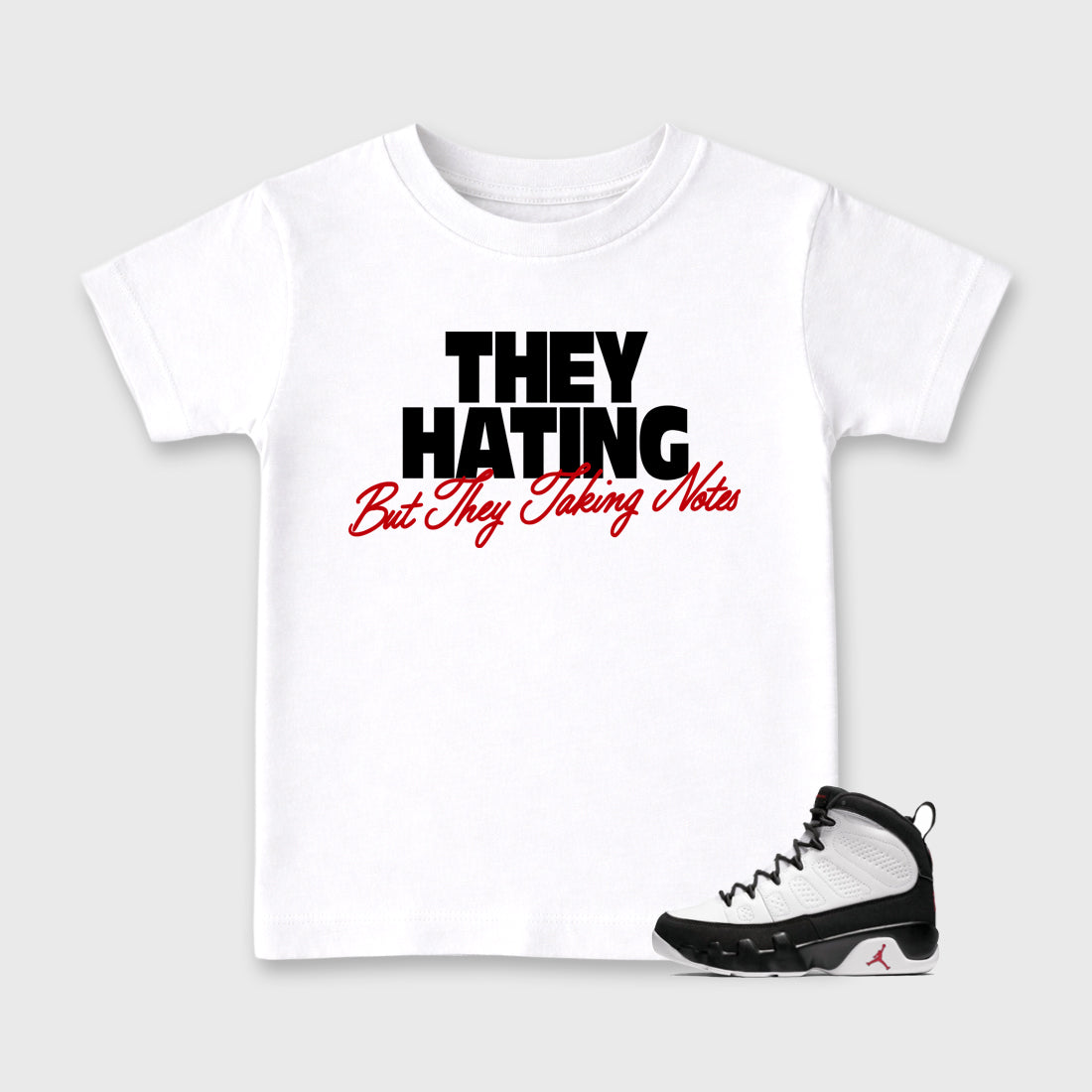 They Hating But Taking Notes Baby & Kids Graphic T-Shirt featuring original artwork designed to match the Air Jordan 9 True Red. White 1 Kids Graphic Tee.