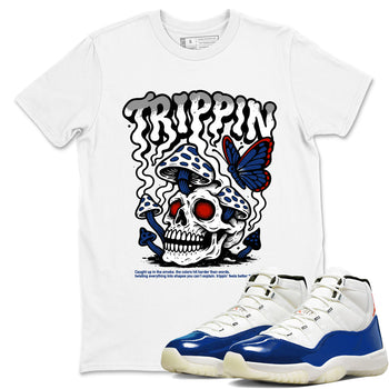 White t-shirt with skull and butterfly design, paired with blue and white sneakers on a white background