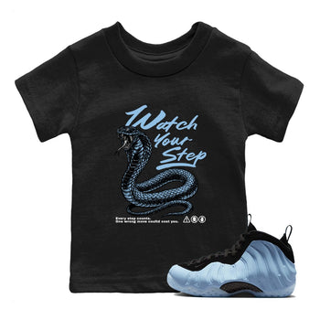 Watch Your Step baby and kids t-shirt crafted for little sneakerheads to shine with the Air Foamposite One Psychic Blue sneakers, displayed in Black 1.