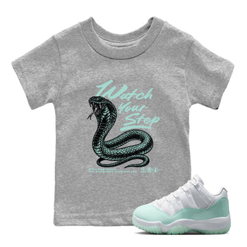 Watch Your Step baby and kids t-shirt crafted for little sneakerheads to shine with the Air Jordan 11 Igloo sneakers, displayed in Heather Grey 1.